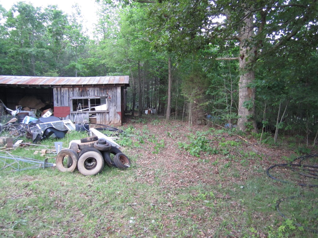 the side of the barn that we cleared last week. see the tires and other junk in the frint? that where we're keeping all things we want to save until we can get into the barn and start organizing!